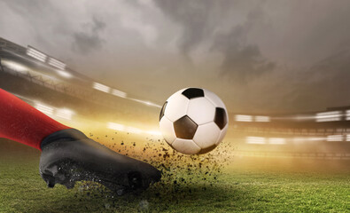 Soccer ball with football player kick off and moving under the spot ray light effects on green field, 3D illustration, of free space for texts and branding. © DESIGN STOCK