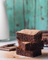 Stack of brownies on a teal wood background.