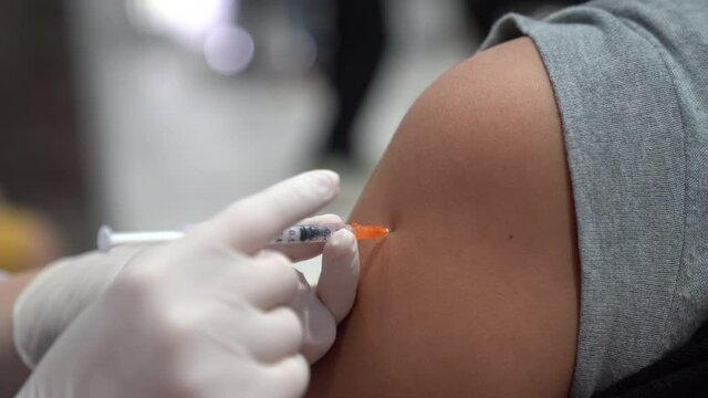 Covid-19 vaccine injection by doctor at hospital. A doctor, nurse injecting coronavirus remedy into an elderly people arm.