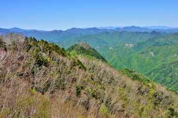 Fototapeta premium 奥秩父の両神山山頂からの展望 秩父山地と八ヶ岳の眺望 奥秩父 両神山（剣ヶ峰）より中央奥が八ヶ岳、右奥が北八ヶ岳、左から小川山、三国山、高天原山（神立山）、大蛇倉山、石仏、御座山、中央左から滝谷山、ブドー沢ノ頭、帳付山、手前左から槍ヶ岳、狩倉山 