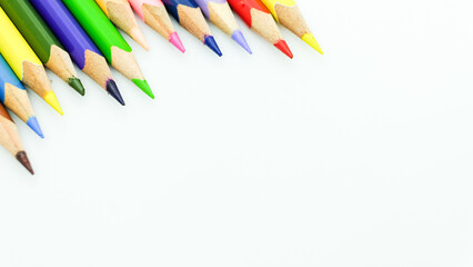 Color pencils border pattern on white background. Isolated closeup shot with space for copy on slide.