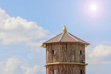 wooden house and round roof on sky background the sun shines