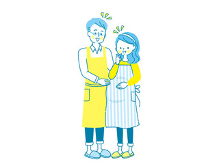 妊娠中の笑顔の女性とエプロン姿の夫