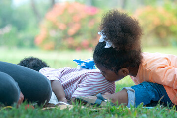 Dark skinned sister kiss her brother with love at park, relax in the public park, love and tenderness