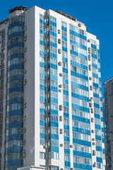 Fototapeta premium A modern multi-storey building with blue windows. Urban landscape