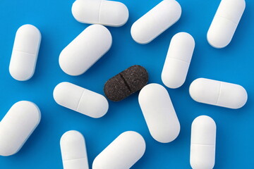 A pile of white oblong tablets lie on a blue background.