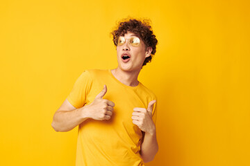 guy with red curly hair yellow t-shirt glasses fashion hand gestures yellow background unaltered