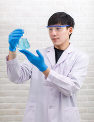 Portrait studio shot Asian professional male scientist in white lab coat rubber gloves standing...