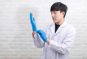 Portrait studio shot Asian professional male scientist in white lab coat rubber gloves standing...