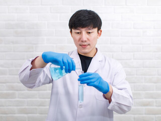 Portrait studio shot Asian professional male scientist in white lab coat rubber gloves standing...