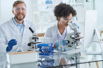 Smiling scientists looking at camera arms crossed in laboratory