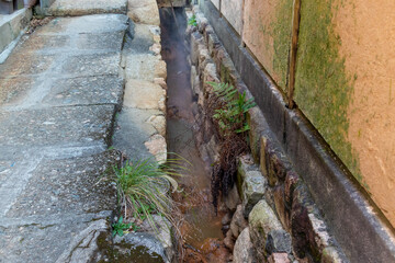 側溝を熱い温泉水が流れる、温泉街の石畳の道