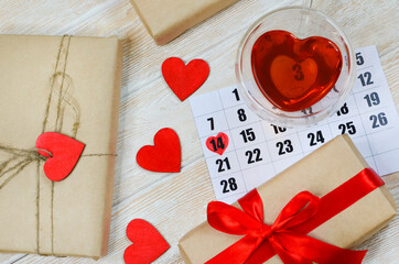 Valentine's Day Calendar 14 february and eco friendly Gifts in craft paper with Red Ribbon, Wooden Heart Shaped Decoration Festive Flat lay, zero waste presents top view