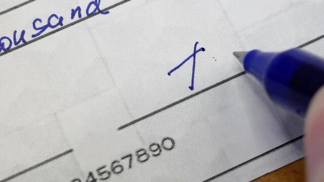 Check Financial Payment, Paycheck in hand on table background, Hand Holding Paycheck Or Payroll Check