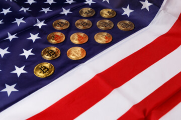 The concept of the economic crisis. Bitcoin gold coins lie on the American flag. Beautiful photo images of gold Bitcoin coins. Cryptocurrency with images of the American flag. Coins close-up.