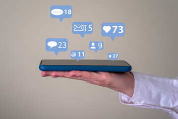 The concept of a communication network. A woman's hand holds a phone with pop-up notification icons.