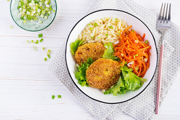 Orzo pasta, carrots and chicken burgers in white bowl. Risoni pasta. Lunch. Top view, above, copy...