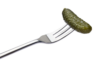 Tasty canned Whole green cornichon on a fork isolated on a white background