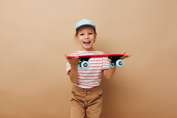 little girl skateboard in hand posing baby clothes fun isolated background