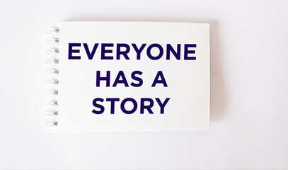Everyone Has A Story text in notepad, white background