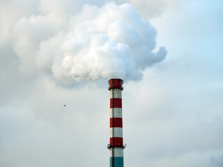 Environmental pollution. The tall chimney releases smoke and steam.
