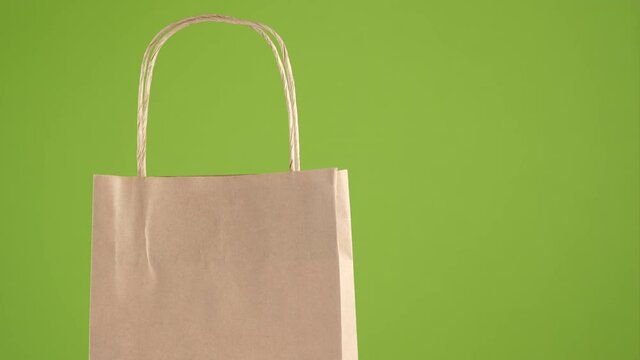 Paper bags for shopping or delivery isolated on green background. People lifestyle concept. 4K UHD video