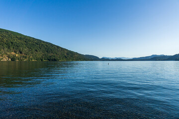 Cultus lake against the beautiful big mountain covered with coniferous forest summer landscape
