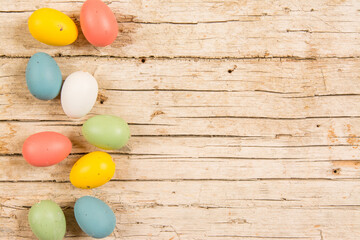 Fototapeta na wymiar Easter background with handmade colored eggs on wooden table. Frame and copy space.