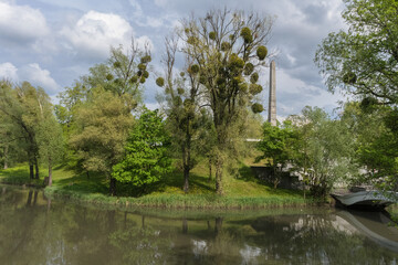 Obraz premium parks landscape with stele and trees pond