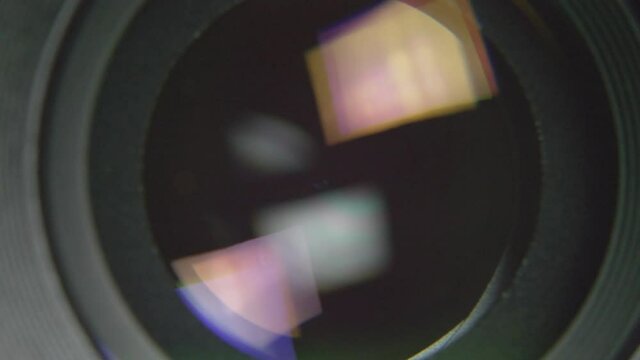 Front close-up view of camera lens diaphragm blades smoothly opening