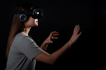Virtual experience, a young woman using virtual reality glasses, playing a game or interacting with...