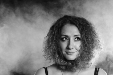 beautiful curly girl portrait black and white in smoke
