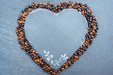 Schieferherz umrandet von Kaffeebohnen als leere Tafel für individuelle Anpassungen