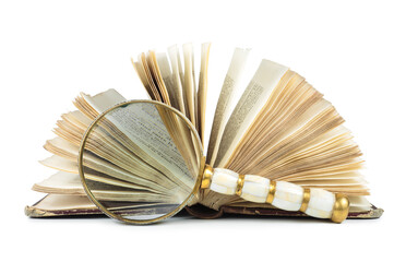 Magnifying glass set in front of antique book with open pages.