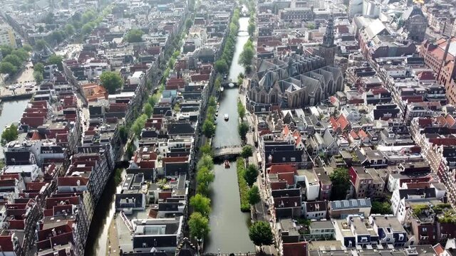 Aerial view of Amsterdam Red Light District moving over on of the canals towards the Oude Kerk or Old Church famous tourist attraction and destination in the Netherlands Europe 4k high resolution