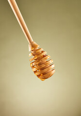 Honey dripping from wooden honey dipper