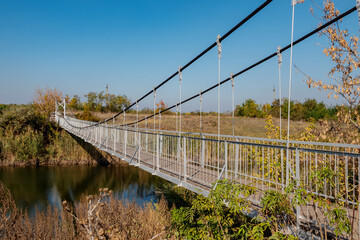 Suspended metal bridge over the river.