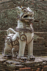 Beautiful ceramic chinthe or singha, a traditional lion guardian and protector at the base of the ancient brick stupa of historic Wat Lok Moli or Lok Molee buddhist temple, Chiang Mai, Thailand