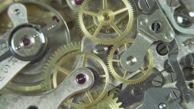 Macro shot of mechanical clock gears rotation synergy