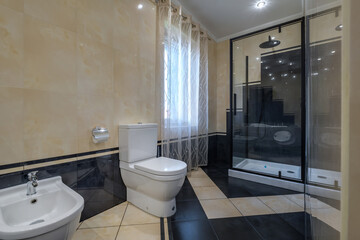 toilet and detail of a corner shower cabin with wall mount shower attachment