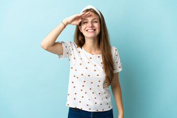 Young caucasian woman over isolated background looking far away with hand to look something