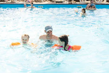 Happy family playing in swimming pool. Summer vacation concept