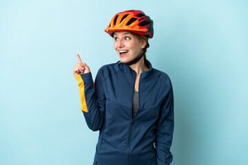 Young cyclist woman isolated on blue background intending to realizes the solution while lifting a finger up