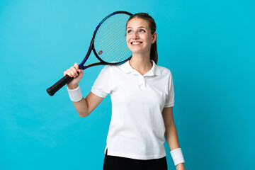 Young woman tennis player isolated on blue background thinking an idea while looking up