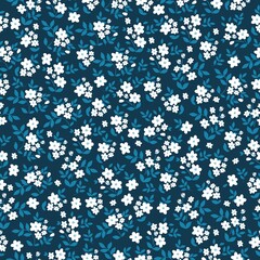 Fototapeta na wymiar Beautiful vintage pattern. Small white flowers and blue leaves. Dark blue background. Floral seamless background. An elegant template for fashionable prints.