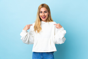 Young Uruguayan blonde woman over isolated blue background with surprise facial expression