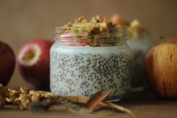 Overnight oats with apple and almonds. Made by soaking rolled oats and chia seeds in milk served with chopped apples, cinnamon, almonds and honey