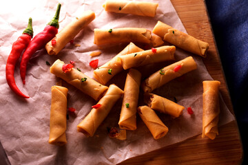 Top down view of Nyonya shrimp rolls on wooden board.