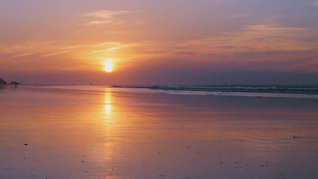 Colorful sunset at the beach in Essaouira, Morocco. 4k. Serene atmosphere with sun reflections. Fantastic nature seascape summer holiday background footage.