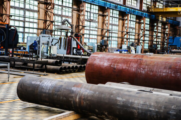 Steel pipes of different diameters in the workshop of an industrial enterprise. Selective focus